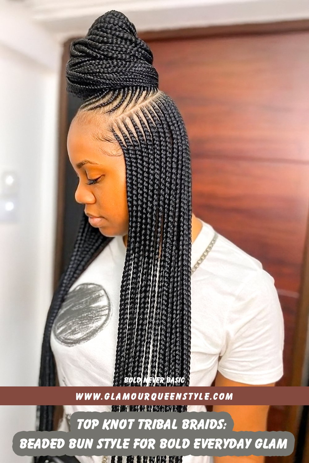 Woman sporting tribal braids woven tightly into an elevated top-knot bun adorned with decorative beads; paired effortlessly with stylish contemporary fashion.