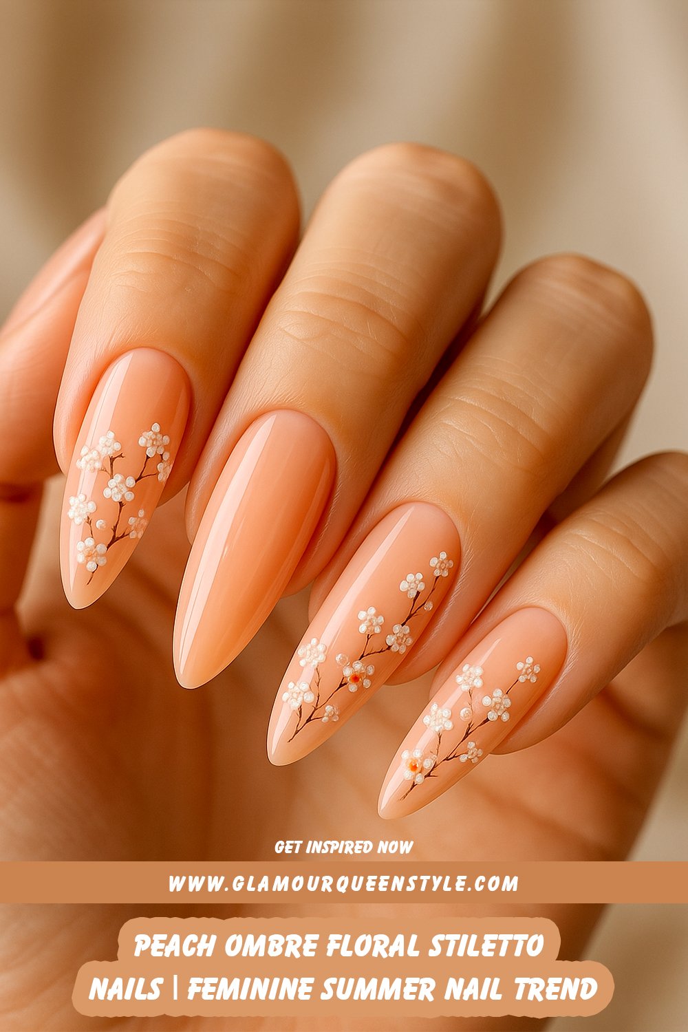 Glossy stiletto nails in a peach ombre design with tiny floral accents; styled alongside modern summer hair trends and light seasonal outfits.