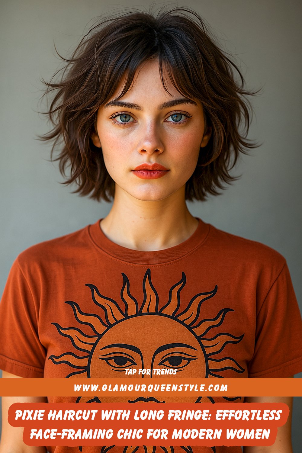 Woman wearing a very short pixie haircut styled with a long side-swept fringe; her eyebrows are softly framed by bangs and she’s dressed in modern chic attire.