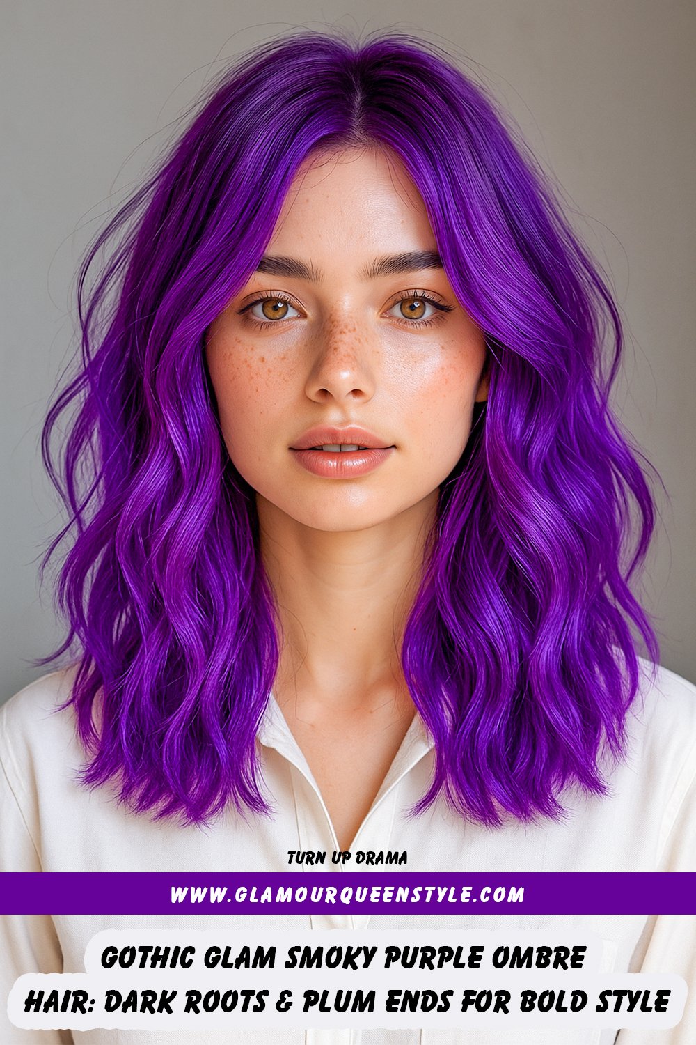 Woman with smoky purple ombre hair featuring dark charcoal roots fading into plum-toned ends; styled straight with bold makeup and wearing a burnt orange button-up shirt.