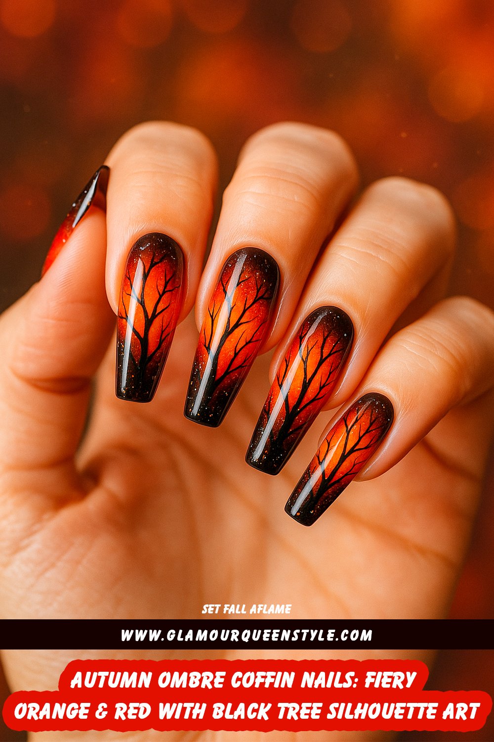Long coffin-shaped nails featuring an orange and red ombré base, decorated with detailed black bare tree branches and scattered white glitter flecks; dramatic and flattering on all skin tones.