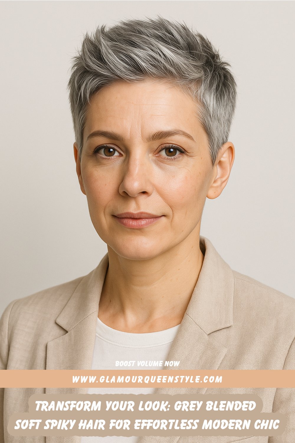 Close-up portrait showcasing stylish grey-blended soft spiky hair on a woman wearing a vibrant magenta blazer and white top; her textured cut is styled forward with uplifted front spikes, creating a chic contemporary beauty statement.