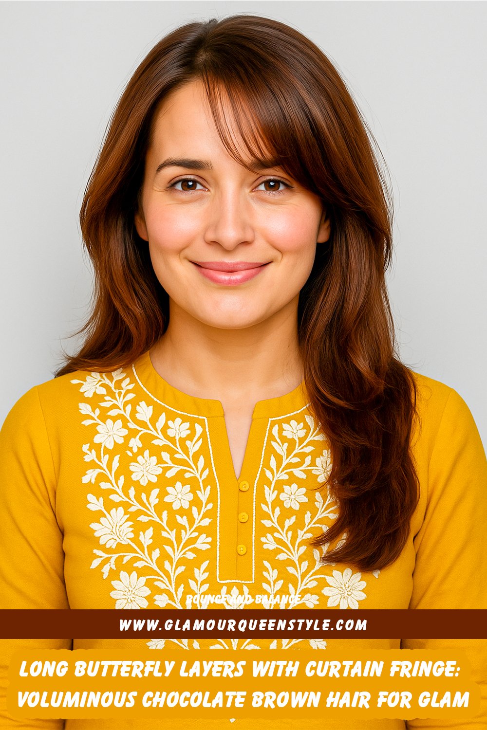 Long chocolate brown hair styled in chunky butterfly layers for extra bounce; features soft feathered curtain bangs framing the face; model wears glowing makeup paired with trendy fashion-forward outfit.