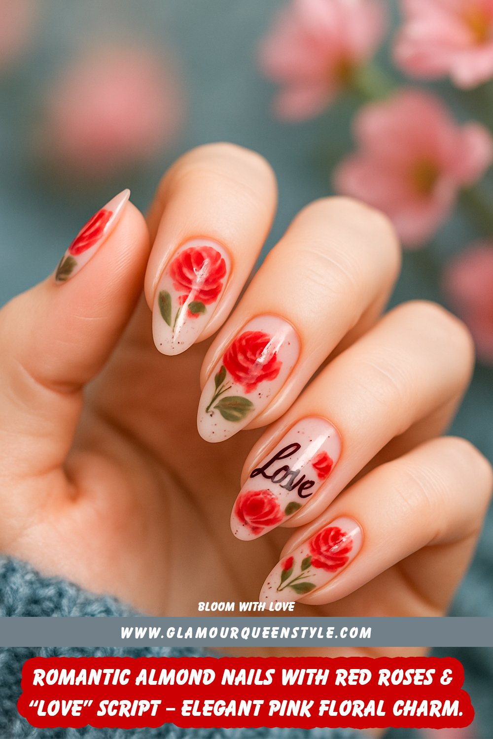 Long almond-shaped nails painted in soft pink; adorned with realistic hand-painted red roses, green leaf accents, one nail scripted “love,” plus scattered dark flecks—all matching wearer’s skin tone.