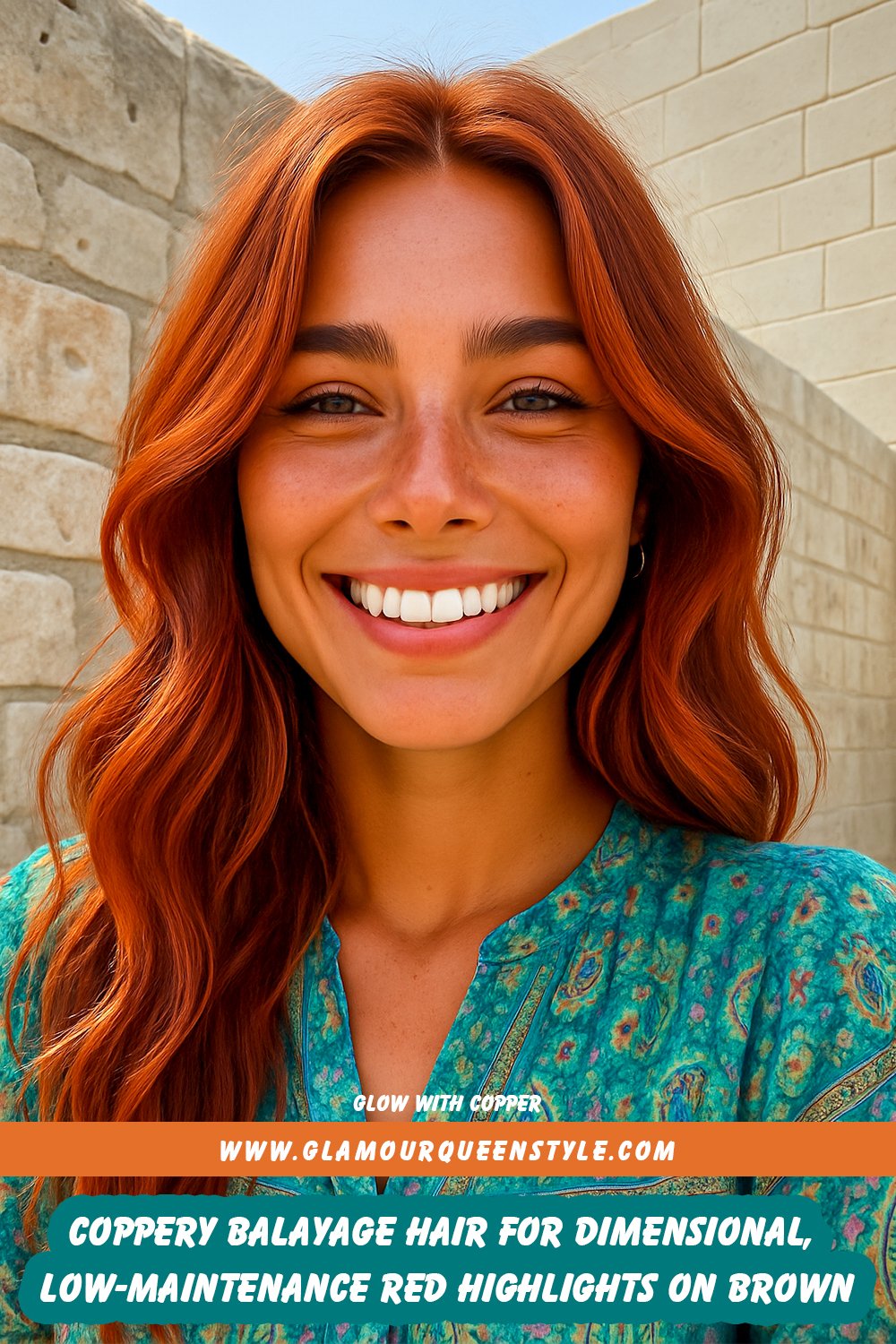Coppery balayage hairstyle with sun-kissed red highlights on brown-blonde base, styled with coral makeup and neutral outfit.